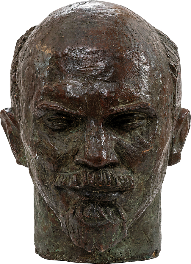 Franciszek Xawery Dunikowski
1875 Kraków – 1964 Warszawa
Głowa Lenina
powstała w 1957 roku
Brąz
48 x 32 x 38 cm
Muzeum Zamoyskich w Kozłówce
MPK/SW/2015

Popiersie przedstawia mężczyznę w średnim wieku lub nawet nieco starszego – Włodzimierza Lenina. Rzeźba wykonana z ciemnego brązu, pokryta zielonkawą patyną, zyskuje klasyczny, niemal pomnikowy wymiar. Patyna dodaje całości szlachetności i historycznego ciężaru, budując wrażenie trwałości i nieprzemijalności.

Twarz jest wyrazista, silnie zarysowana – dominuje wysokie, wypukłe czoło oraz mocno zaznaczone łuki brwiowe, pod którymi kryją się głęboko osadzone oczy. Ich spojrzenie – lekko przymrużone, przenikliwe – sprawia wrażenie skupionego, analizującego, niemal oceniającego. Prostoliniowy nos oraz ściśle zaciśnięte usta wzmacniają surowy wyraz twarzy, nad którym góruje precyzyjnie opracowany wąs. Krótka broda dopełnia starannie wymodelowana kompozycję, jakby wycięta z brązu ostrzem determinacji.

Czaszka niemal całkowicie łysa, z jedynie śladowym zaznaczeniem krótkich włosów po bokach, kontrastuje z silnie wymodelowaną dolną partią twarzy. Uszy – odstające, lekko asymetryczne – wprowadzają nutę realizmu do niemal ideowego portretu.

Powierzchnia rzeźby nie została całkowicie wygładzona – widoczne są ślady modelowania, drobne nierówności i ścieżki dłoni rzeźbiarza. To świadoma decyzja artystyczna – struktura materiału podkreśla surowość i bezpośredniość postaci, nadając jej autentyczność i wewnętrzną siłę.

Całość emanuje powagą, skupieniem i nieugiętością. To nie tylko realistyczne przedstawienie konkretnej postaci, lecz także uosobienie władzy, kontroli i ideologicznej pewności. Rzeźba działa nie tylko formą, ale też nastrojem – dominującym, świadomym i niepodważalnym.
